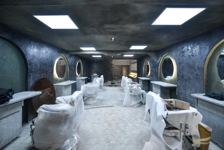 a large bathroom with three sinks and many chairs