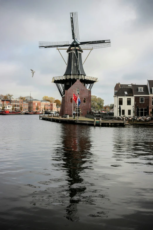 a view of a harbor with a boat and windmill