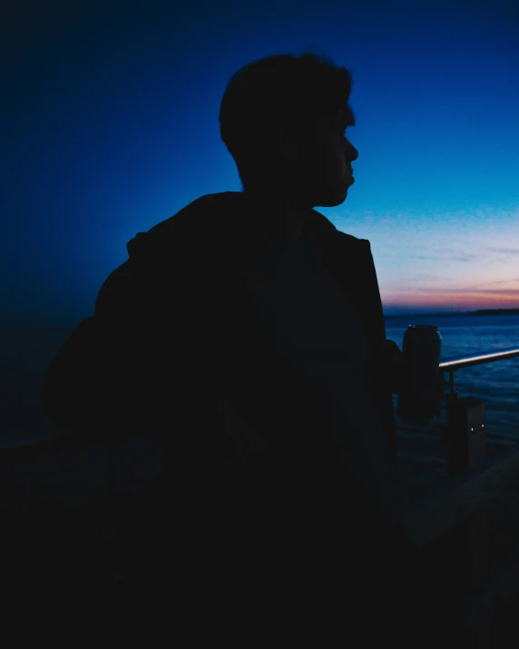 a man stands on a dock looking out at the water