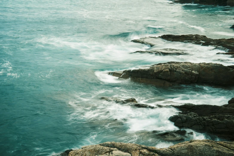 an aerial view of some rocks in the water