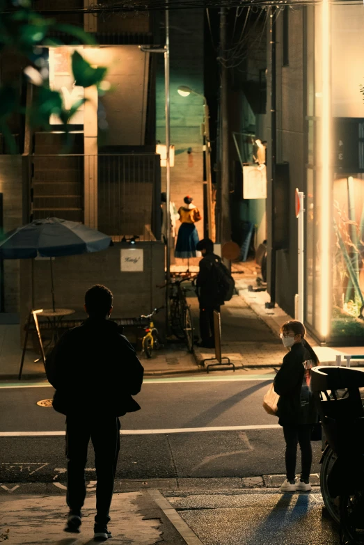 people walking on the sidewalk in the dark