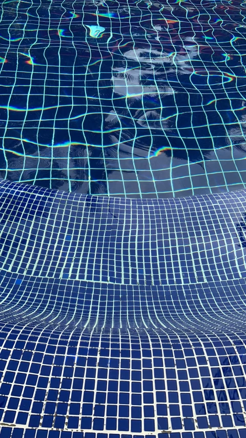 a man is standing by a large swimming pool