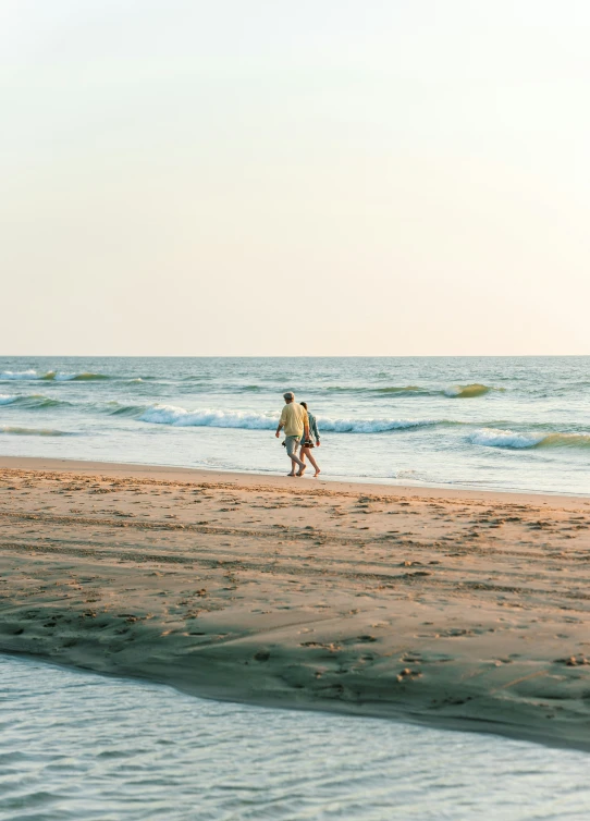 a man with a surf board is walking along the beach