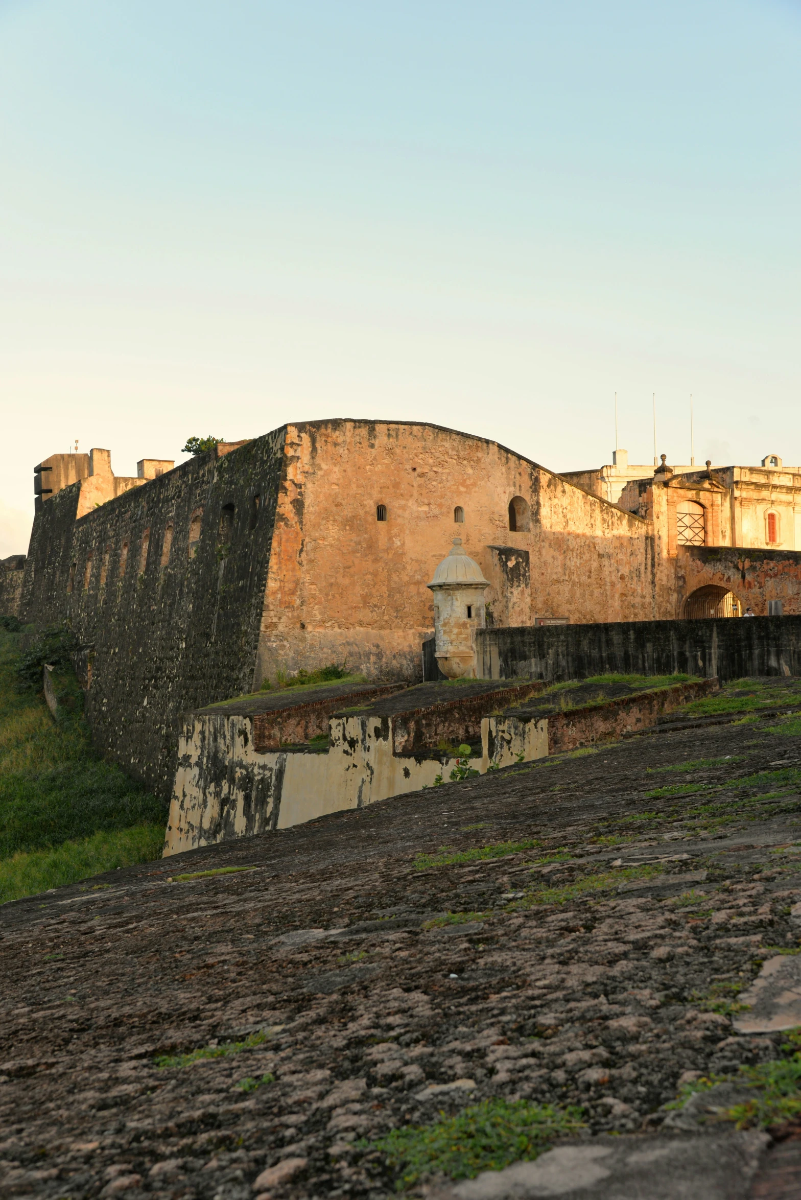 a very old structure near some buildings on a hill