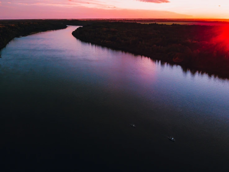 the sun is setting over a large river