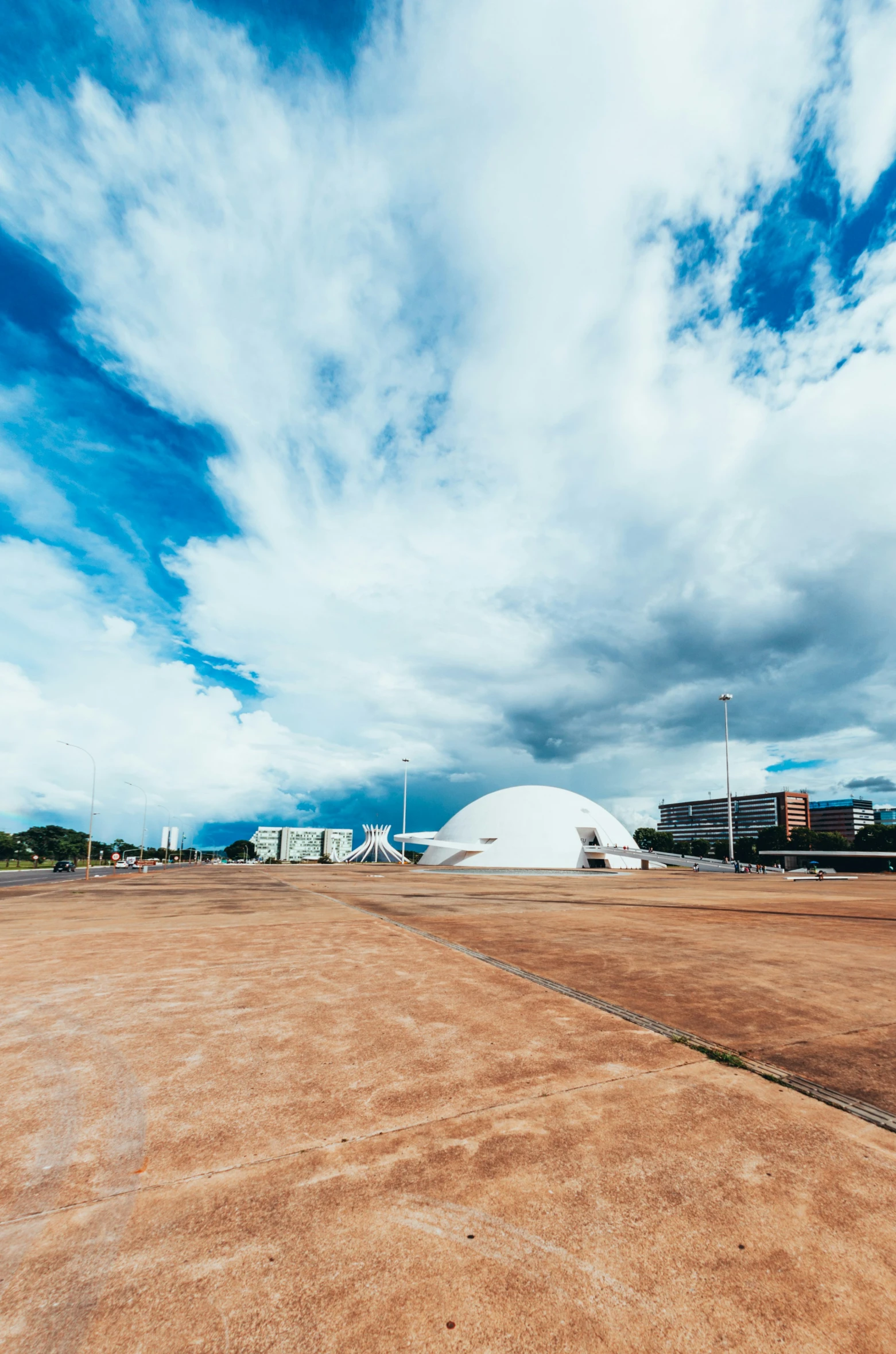 clouds hovering over an airport with a large white dome