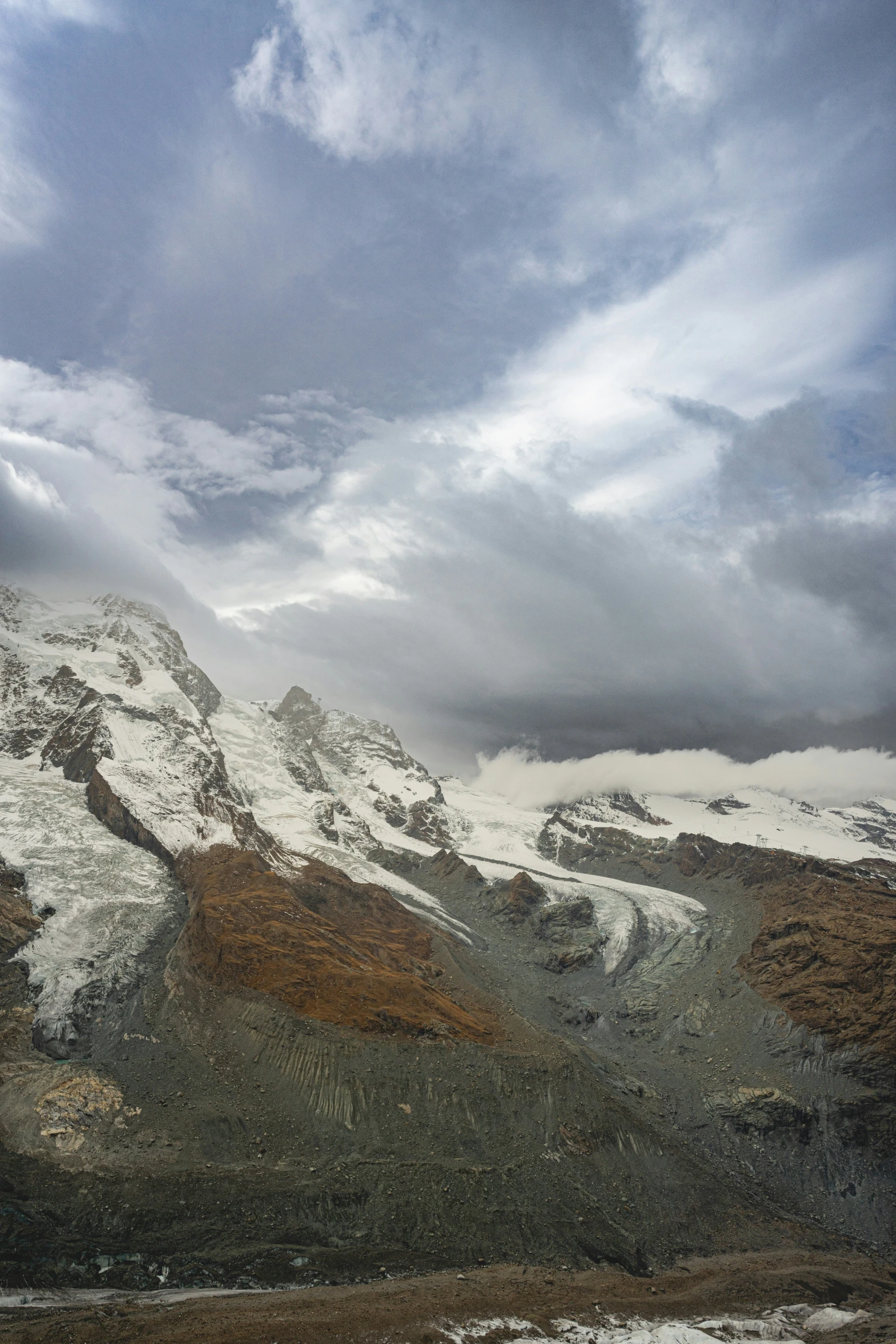 a mountain in the distance under snow and clouds