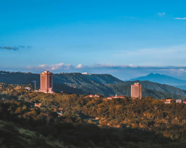 there are some tall buildings nestled on the mountains