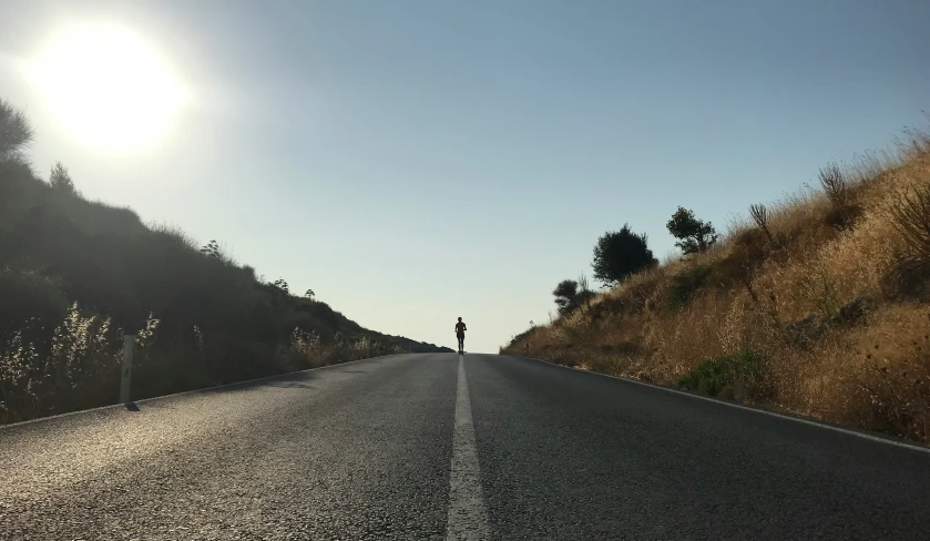 a person stands on the side of an empty street