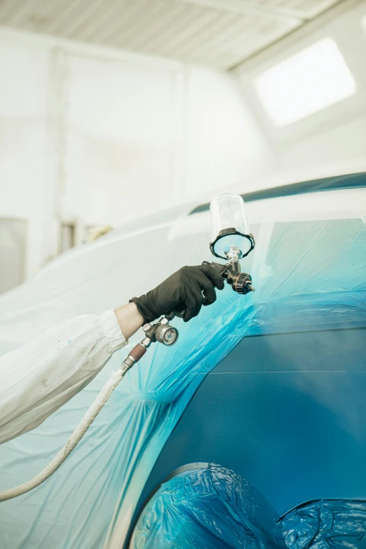 a person's hand with rubber gloves holding onto a machine