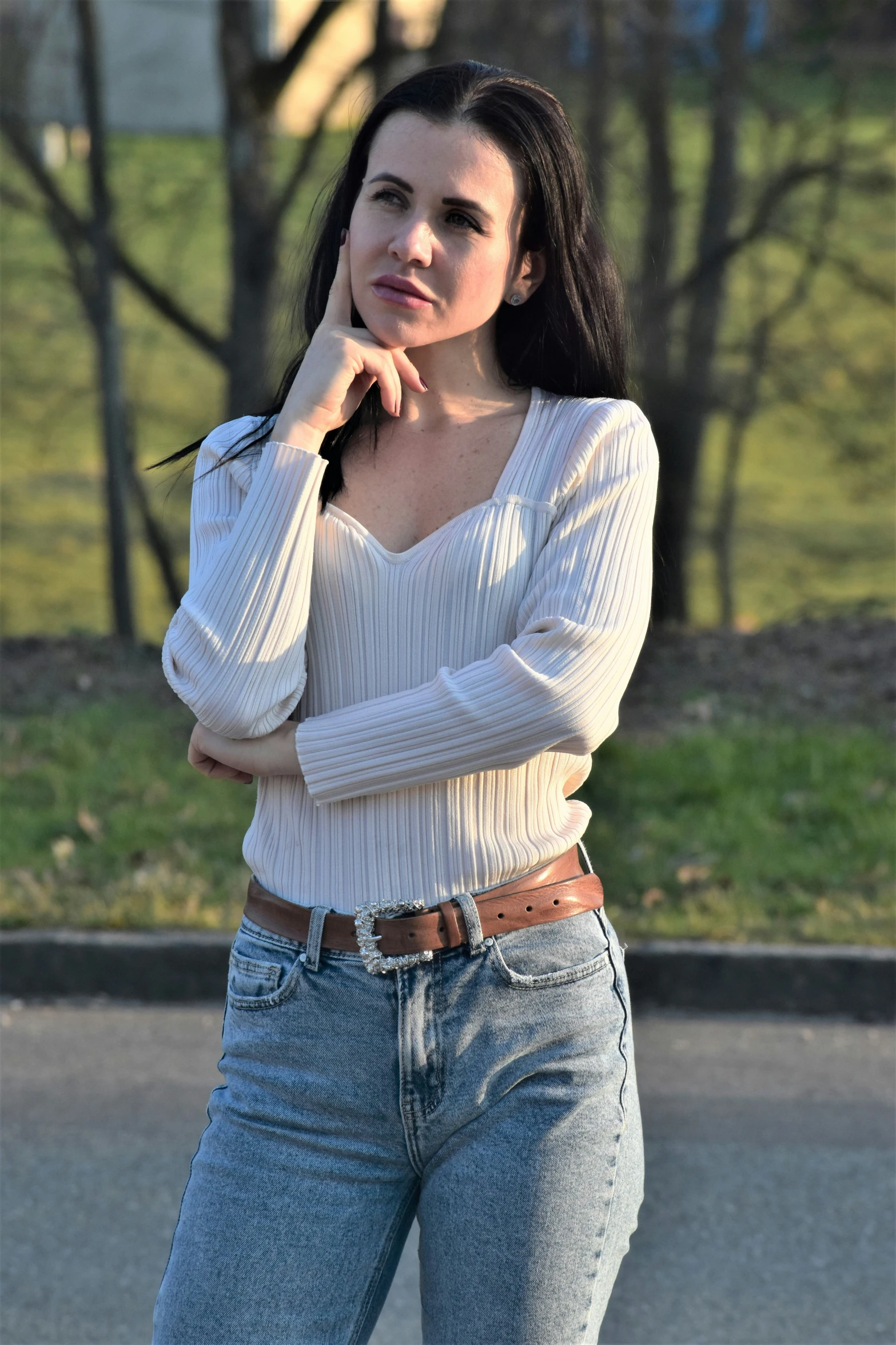 a beautiful woman in jeans is posing for the camera