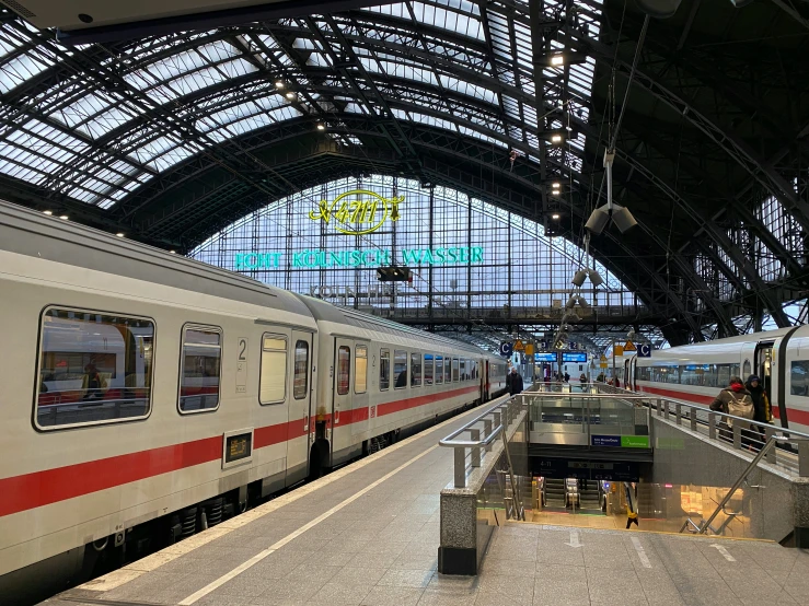 a passenger train pulled into the terminal with people standing on the platform