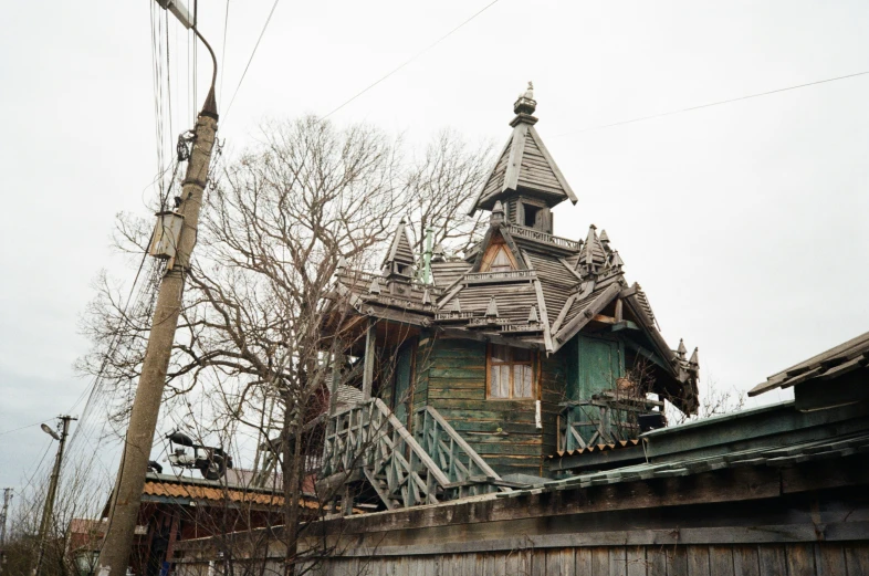 an old house with a clock tower next to a tree