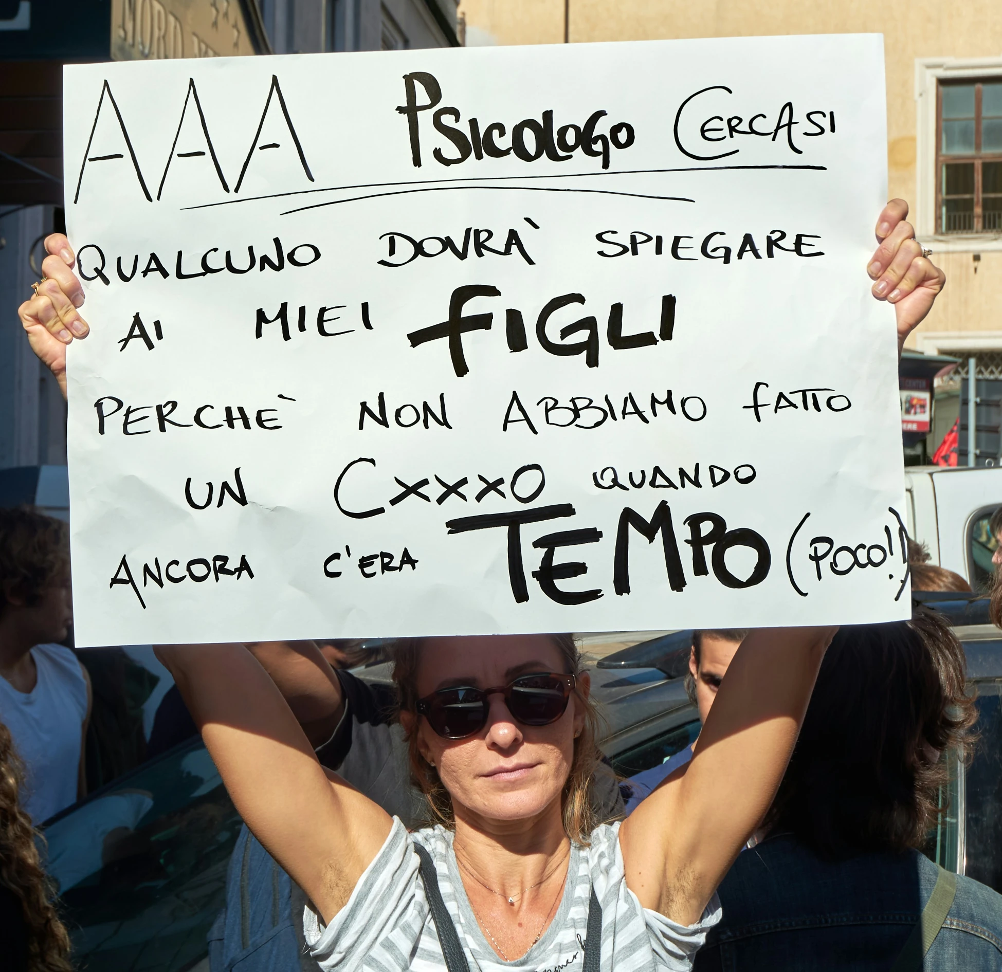 a woman holding up a white sign that says, i'm sorry