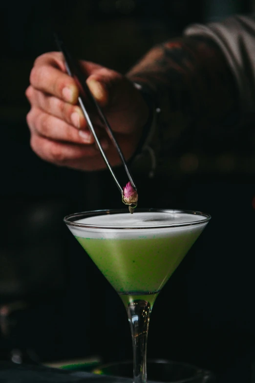 a person  into a green drink in a glass