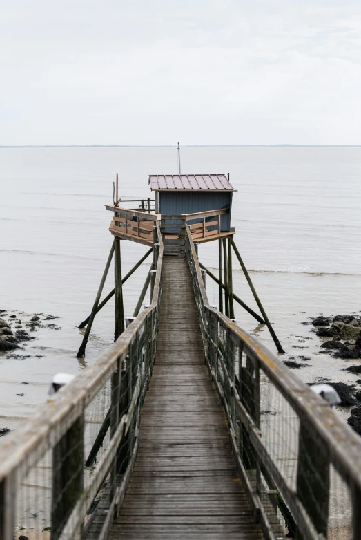 a pier with a building on top of it near the water