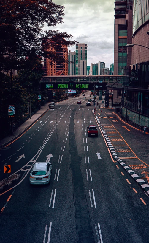 there is a city street with cars driving down it