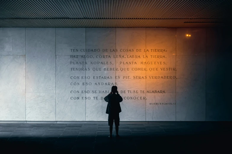 a woman in a dark room with words on the wall