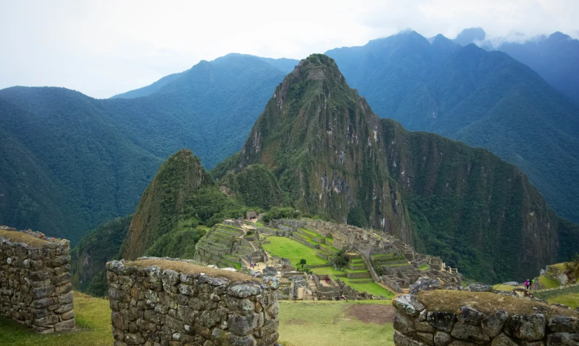 the machana ruins and surrounding mountains with clouds over them