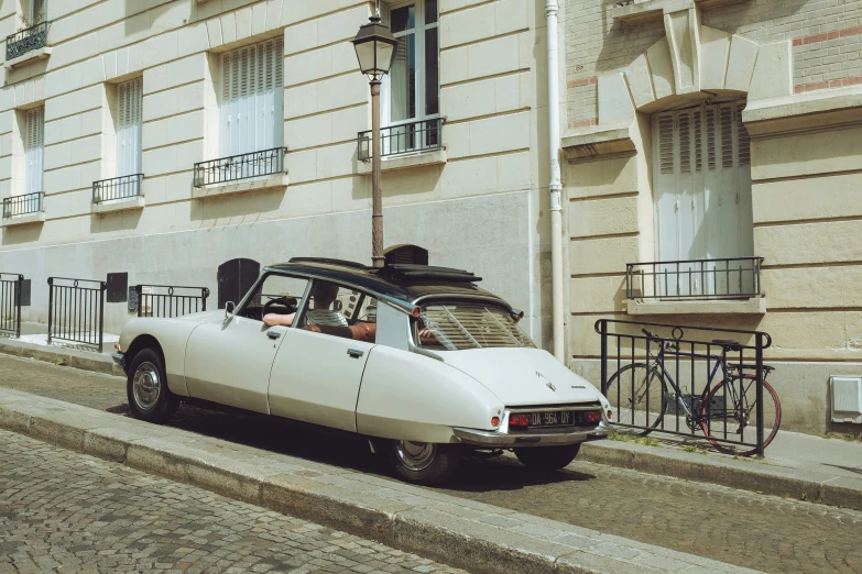 a car sitting in front of a building near a bike