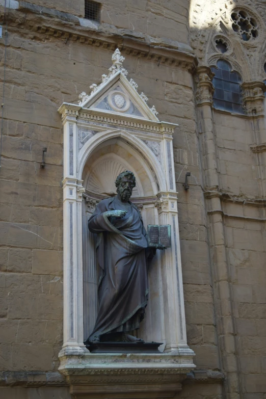 a statue stands on top of a stone pedestal