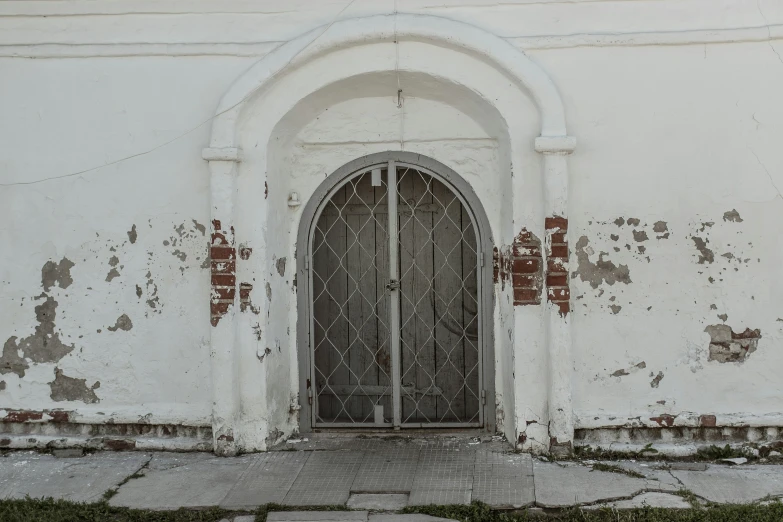 an old doorway in a wall with grass