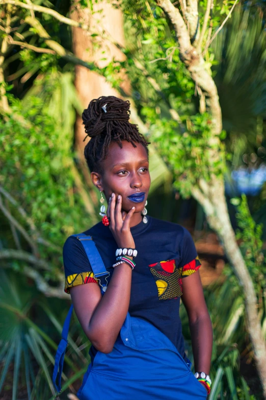 a young lady in blue with some beads talking on the phone