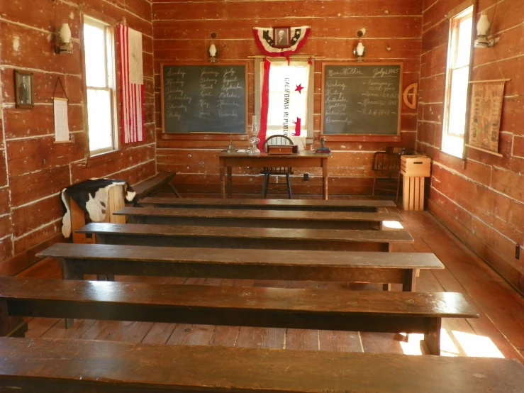 a room with wooden floors and a blackboard on the wall