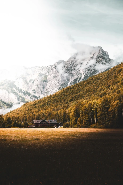 mountains covered in trees and green grass with a long building in the foreground