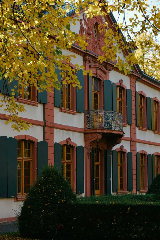 the building has green shutters and yellow windows