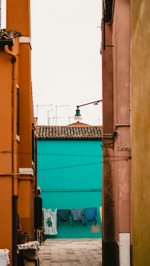 a blue building and clothes lines with a roof