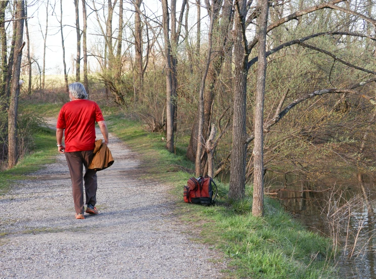 a person walking down the road with a red bag