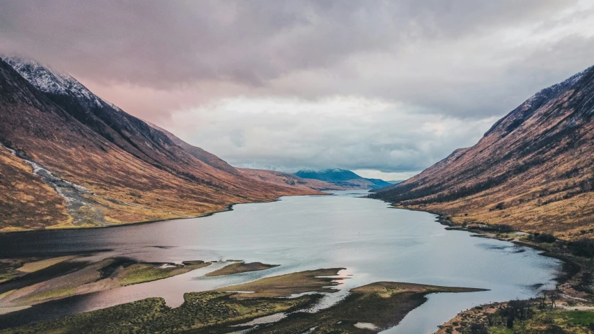 a view down to some mountains with water below