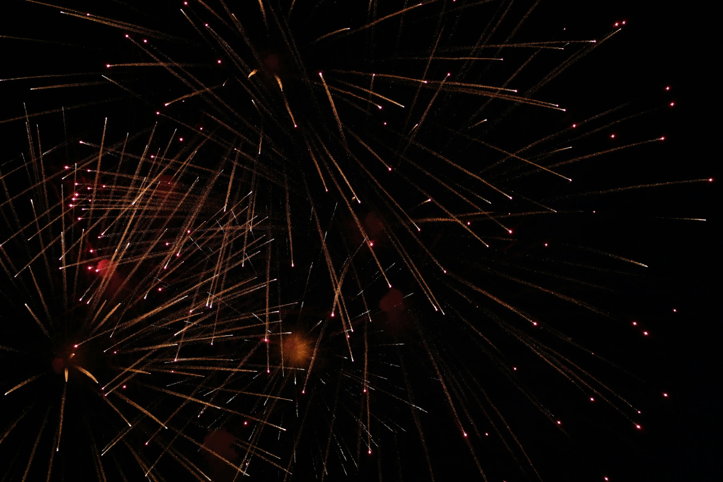 a black sky with many colorful fireworks at night