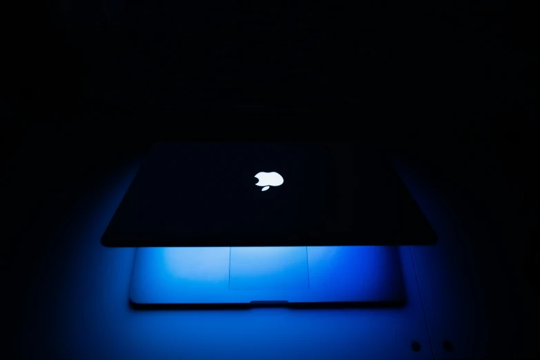 apple computer illuminated up in the dark room