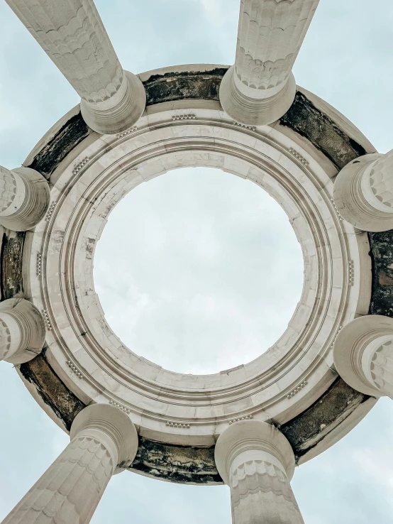 the bottom view of a round structure with white pillars