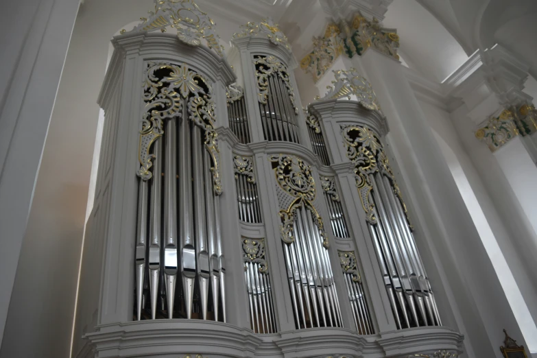 a silver pipe organ in the center of a building