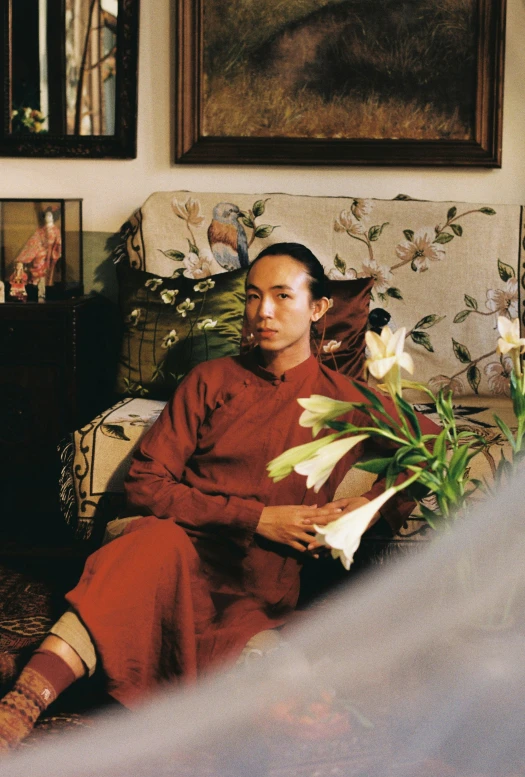 an oriental woman sitting on a couch with flowers