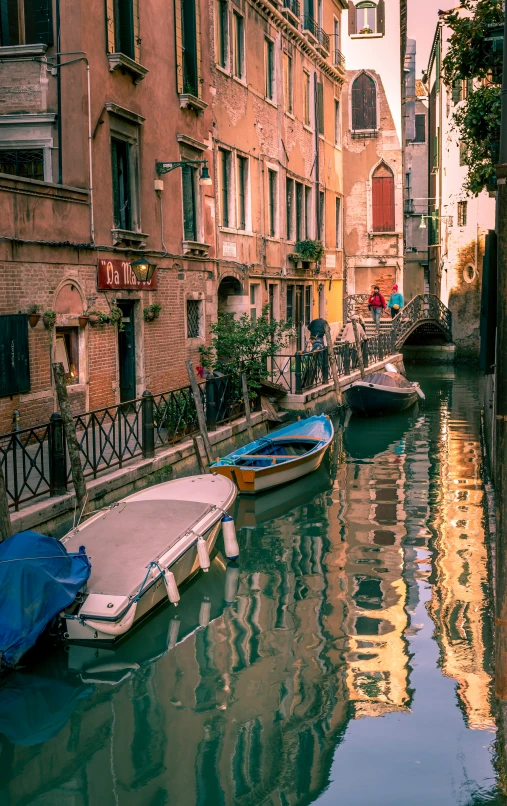 some boats are tied to some buildings on the river