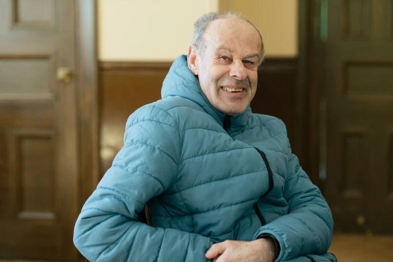 the man is dressed in a turquoise coat