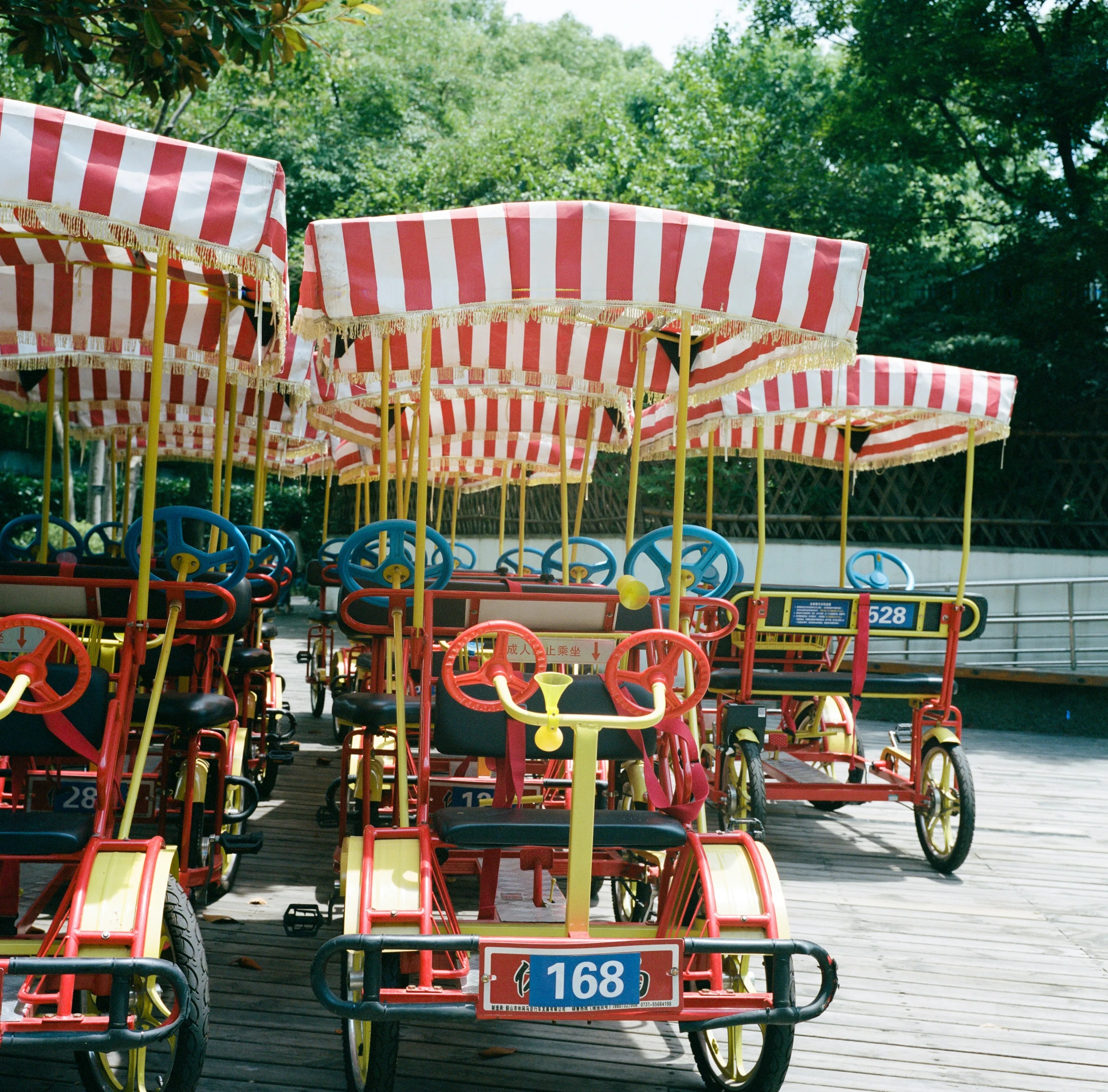 the miniature rides are decorated with giant striped circus tents