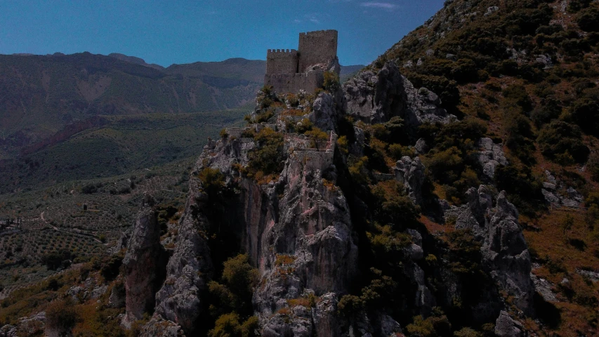 a castle is on top of a rocky cliff