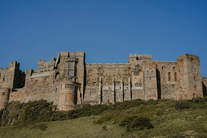 a stone castle atop a grassy hill