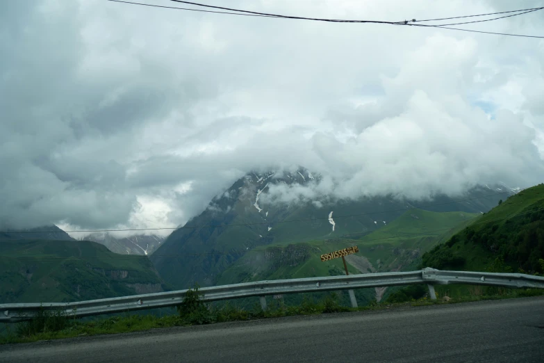 a view from the side of a road and mountains