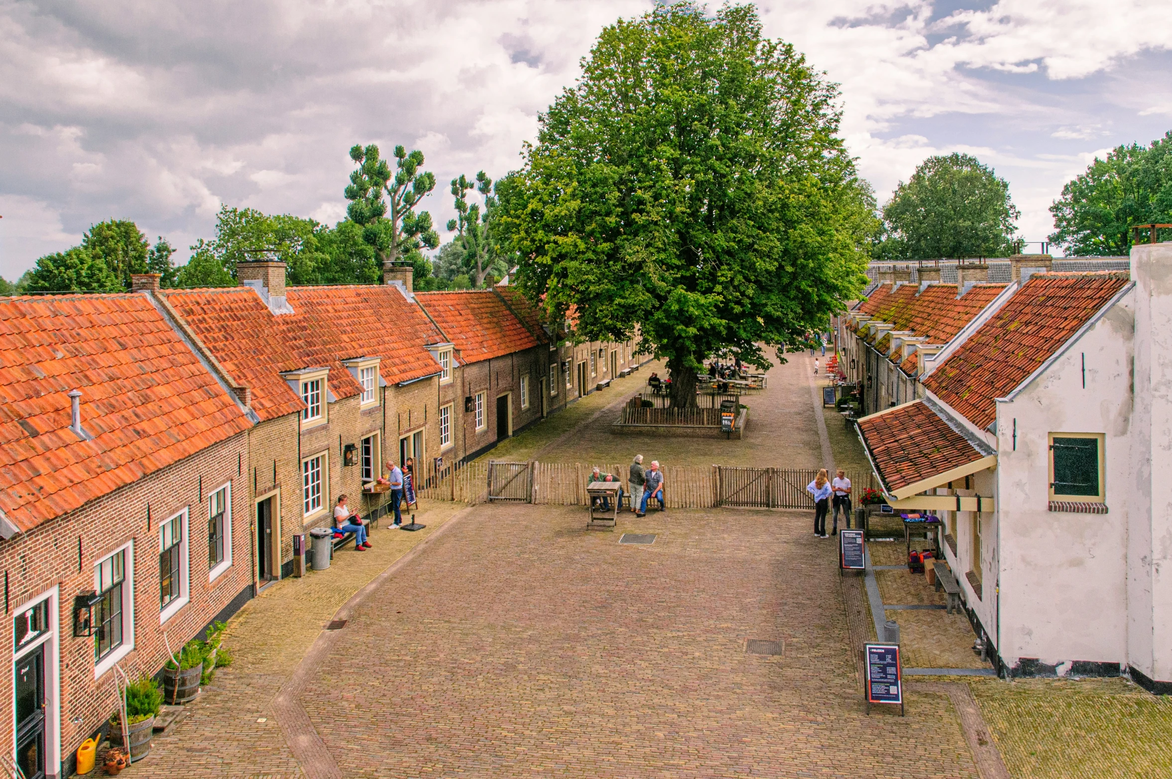 people sitting on benches outside of small houses