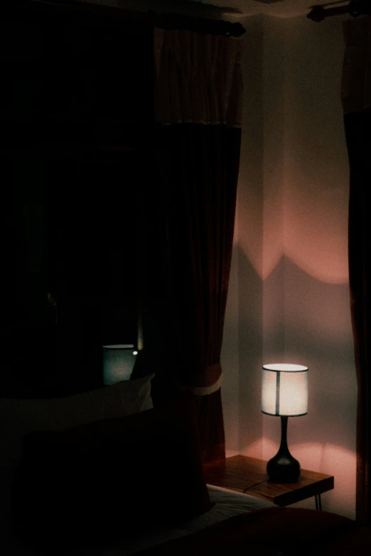 lamp shining on dimly lit area in dark room