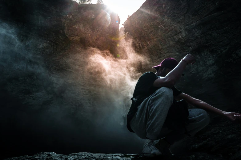 a person sits on a ledge overlooking the river