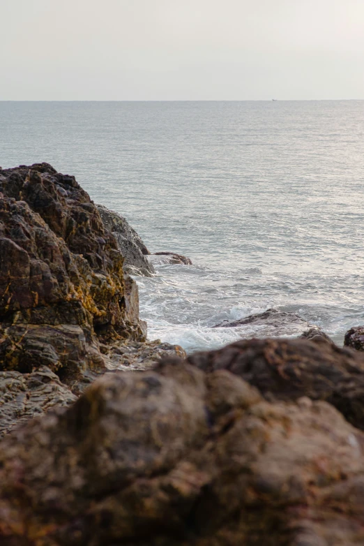 a rocky outcropping with the ocean in the background