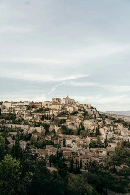 a town perched on a hillside with trees on both sides