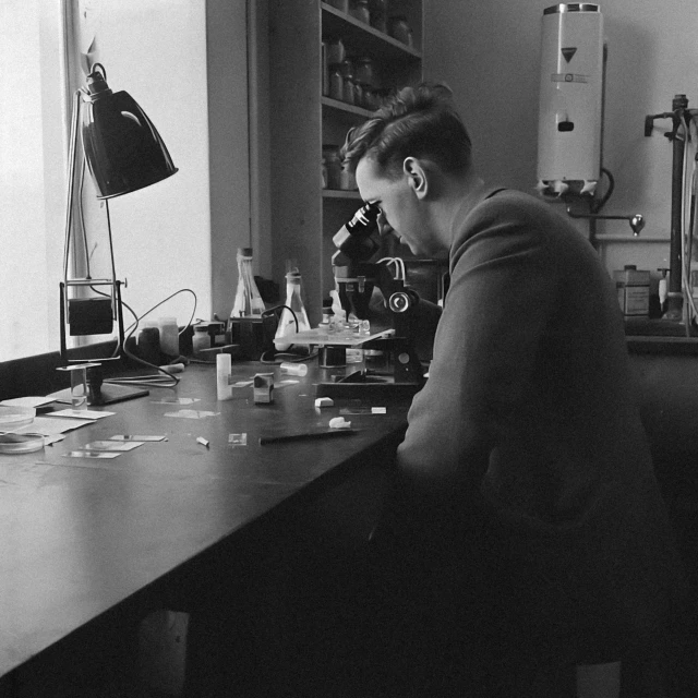 a man sitting at a desk looking down in the laboratory